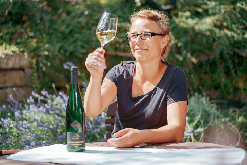 Junglandwirtin Elisabeth Born mit einem Glas Wein im Garten
