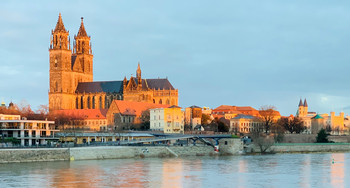 Das Foto zeigt den Magdeburger Dom mit der Elbe davor.
