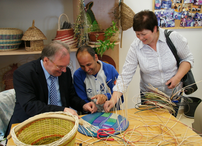 Amos Kadosch, einer der rund 120 Bewohner von Beit Uri, zeigt Ministerpräsident Dr. Reiner Haseloff und der Landtagsabgeordneten Gabriele Brakebusch in der Korbflechtwerkstatt seine Fertigkeiten.