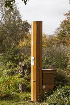 Bienenbehausung in Form eines Schlotes auf einer Grünfläche