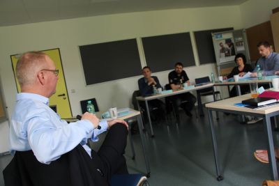 In einem Schulungsraum sitzt Professor Hoffmann vor den Seminarteilnehmern. (Bildquelle: Ministerium der Finanzen des Landes Sachsen-Anhalt)