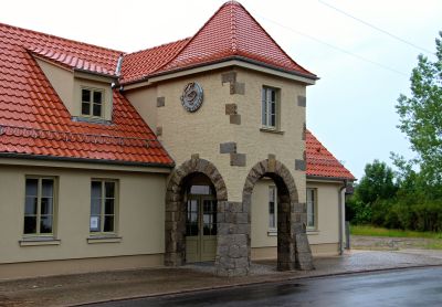 Aussenansicht Bürgerhaus: Zweistöckiges Gebäude mit Türmchen und rotem Dach.
