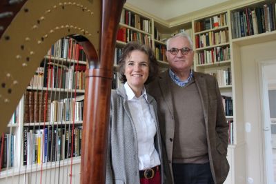 Eine Frau und ein Mann stehen in einer Bibliothek, vor Ihnen steht eine Harfe. Foto: Landesministerium der Finanzen Sachsen-Anhalt