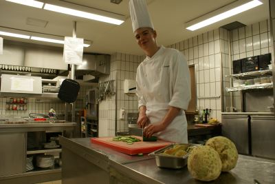 Florian Schiebel steht in der Hotelküche und schneidet Gemüse