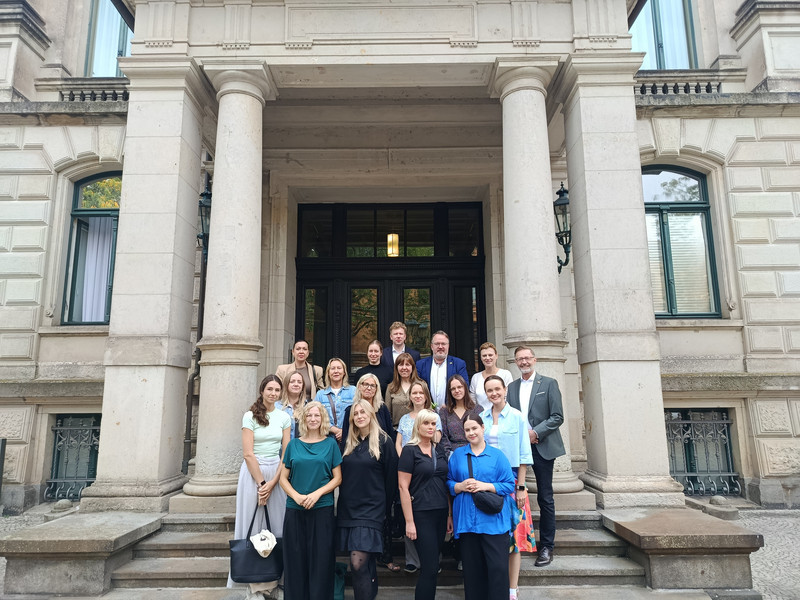 250910 Besuch Fachrkräfte Hort Masowien Eine Gruppe von etwa 15 Frauen und 3 Männer stehen auf der Treppe draußen. Im Hintergrund sind vier Säulen und der Eingang der Staatskanzlei.