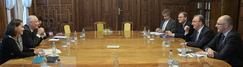 Das Bild zeigt links unter anderem den ungarischen Minister Balog und rechts Ministerpräsiddent Haseloff an einem Beratungstisch vor holzgetäfelter Wand.