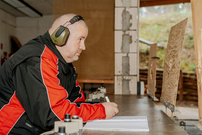 Das Bild zeigt den Vorsitzenden des Jerslebener Schützenvereins Ralf Geipel mit Kopfhörern beim Aufschreiben.
