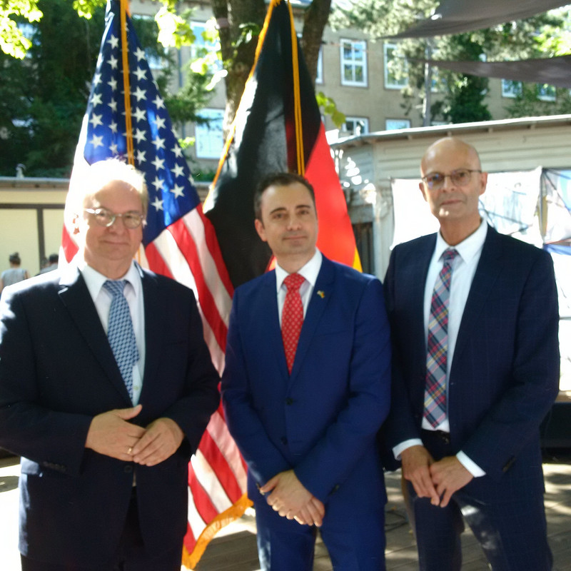 Das Bild zeigt von links Ministerpräsident Haseloff, Generalkonsul Eydelnant und Halles Oberbürgermeister Wiegand vor den Fahnen der USA und Deutschlands.
