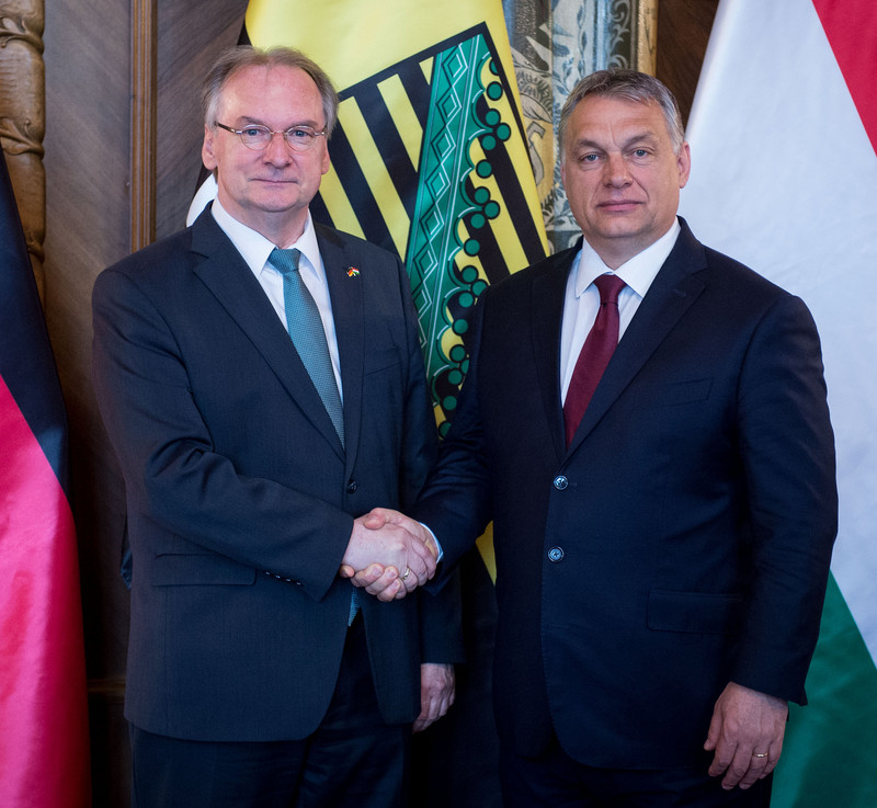 Das Bild zeigt links Ministerpräsident Haseloff und rechts den ungarischen Ministerpräsidenten Orban beim Handschlag zur Begrüßung vor den Fahnen Deutschlands, Sachsen-Anhalts und Ungarns.