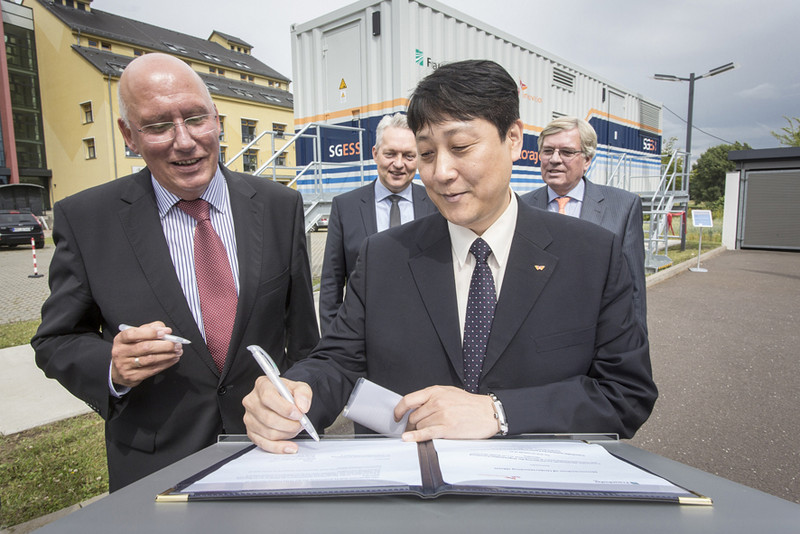 Foto: Dirk Mahler/Fraunhofer IFF Das Bild zeigt Professor Schenk (Leiter Fraunhofer-Institut) und Hojin Ryu (SK Innovation) bei der Unterzeichnung der Kooperationsvereinbarung. Im Hintergrund zu sehen sind Minister Möllring und Professor Verl (Vorstand der Fraunhofer-Gesellschaft).