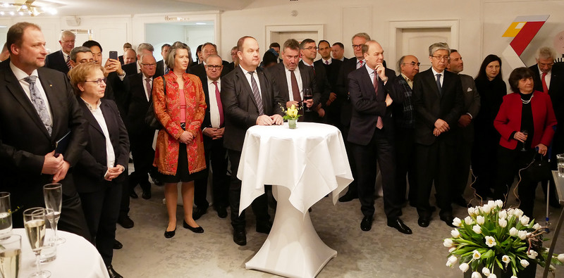 Das Bild zeigt einige der beim Neujahrsempfang anwesenden Diplomaten an Stehtischen während der Rede des Ministerpräsidenten.