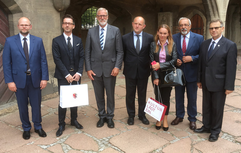 Das Bild zeigt die fünfköpfige Delegation aus Kujawien-Pommern sowie Kulturminister Rainer Robra und den Direktor des Kunstmuseums Moritzburg, Thomas Bauer-Friedrich im Innenhof des Museums.