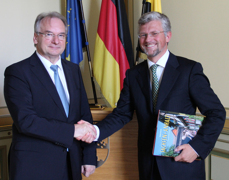 Das Foto zeigt links Ministerpräsident Dr. Reiner Haseloff und rechts den Botschafter der Ukraine, Dr. Andrij Melnyk vor den Fahnen der EU, Deutschlands und Sachsen-Anhalts.