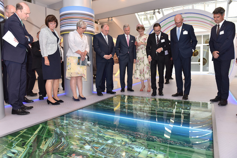 Das Bild zeigt unter anderem das Königspaar, das im Besucherzentrum des Chemieparks Leuna auf ein im Boden eingelassenes großes Bild des Industriekomplexes blickt.