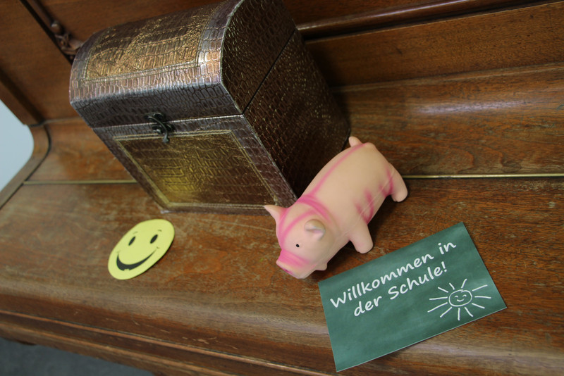 Das Bild zeigt eine Schatztruhe und ein Glücksschwein.