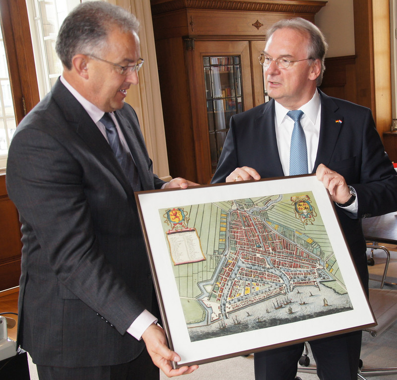 Das Foto zeigt links Rotterdams Bürgermeister Aboutaleb, der Ministerpräsident Haseloff einen alten Stadtplan von Rotterdam überreicht.