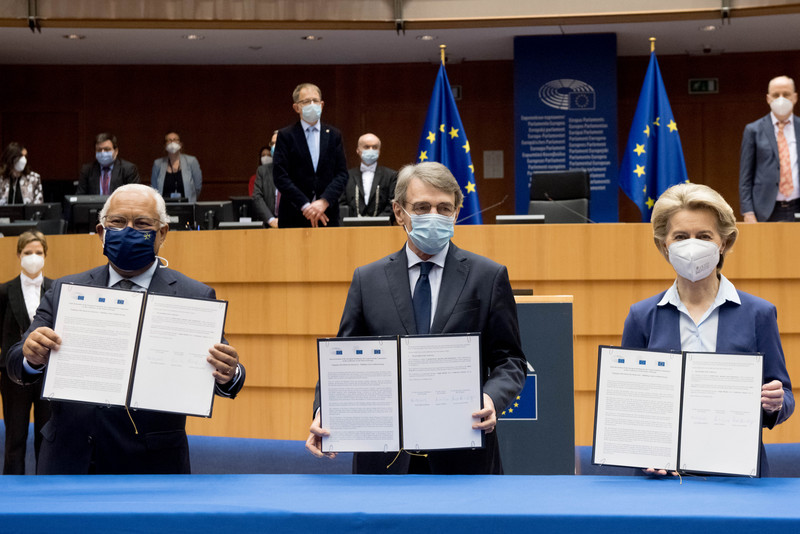 EU-Ratspräsident Antonio Costa, David Sassoli als Präsident des Europäischen Parlaments und Ursula von der Leyen, EU-Kommissionspräsidentin halten je eine unterzeichnete Version der Gemeinsamen Erklärung in der Hand. Im Hintergrund ist ein Stück des Plenarsaals des Europäischen Parlaments zu sehen.