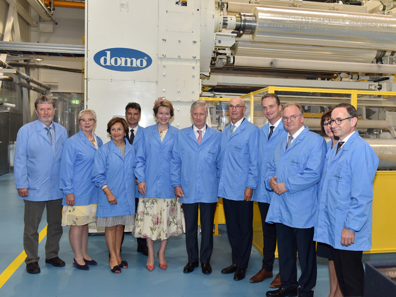 Das Bild zeigt unter anderem das Königspaar in blauen Kitteln vor einer Folienanlage der DOMO Caproleuna GmbH.