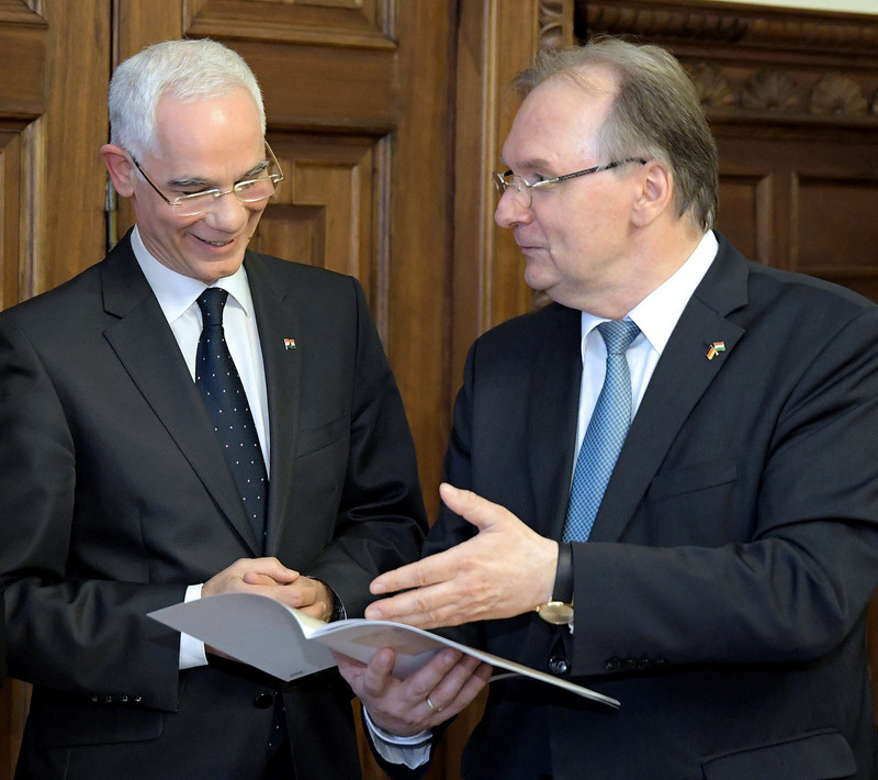 Das Bild zeigt links Minister Balog und rechts Ministerpräsident Haseloff, der ein Heft mit Dokumenten aus der Studienzeit des Ministers in Halle (1981-1983) überreicht.