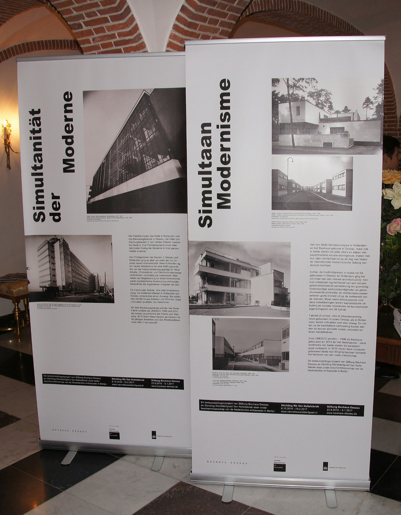 Das Bild zeigt zwei mit Fotos und Texten bedruckte Roll-ups, mit denen die Gäste des Empfangs auf die aktuell in Dessau und Rotterdam gezeigte Ausstellung "Simultanität der Moderne" aufmerksam gemacht wurden.