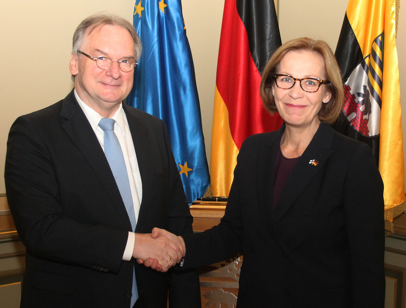 Das Bild zeigt links Ministerpräsident Reiner Haseloff und rechts Botschafterin Ritva Inkeri Koukku-Ronde vor den Fahnen der EU, Deutschlands und Sachsen-Anhalts.