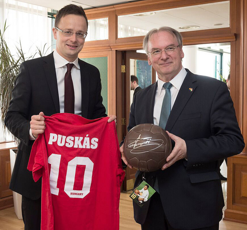 Das Bild zeigt links Außenminister Szijjártó, der Ministerpräsident Haseloff (rechts) ein Trikot und einen Ball mit dem Namenszug der Fußballlgende Ferenc Pukás überreicht.