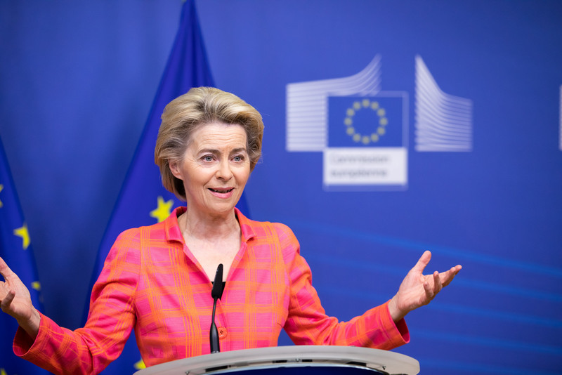 Das Foto zeigt Kommissionspräsidentin Ursula von der Leyen an einem Rednerpult stehend vor blauem Hintergrund mit EU-Fahne und dem Logo der Europäischen Kommission.