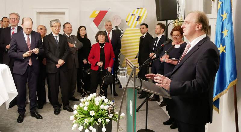 Das Bild zeigt rechts Ministerpräsident Haseloff an einem Rednerpult vor den Fahnen der EU und Sachsen-Anhalts bei seiner Ansprache vor Diplomaten aus aller Welt.