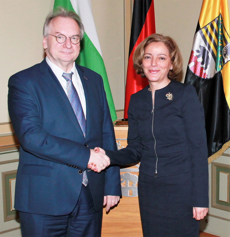 Das Bild zeigt links Ministerpräsident Haseloff und rechts Botschafterin Radkova Shekerletova vor den Flaggen der Bulgariens, Deutschlands und Sachsen-Anhalts. 