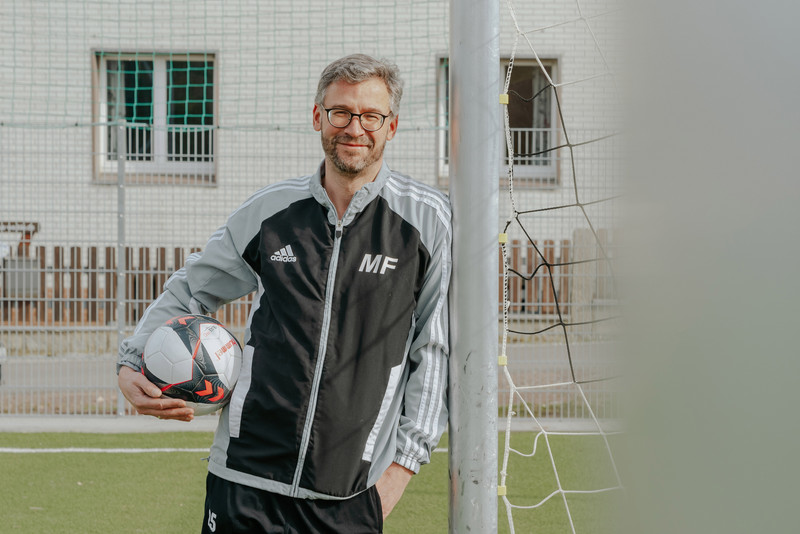 Das Bild zeigt Maik Fiebiger, Präsident des SV Darlingerode, mit einem Ball unterm Arm auf dem neuen Kunstrasenplatz.