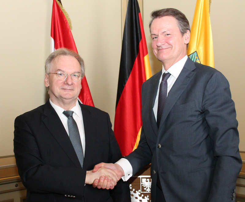 Das Foto zeigt links Ministerpräsident Haseloff und rechts Botschafter Kingma beim Handschlag zur Begrüßung vor den Flaggen der Niederlande, Deutschlands und Sachsen-Anhalts.