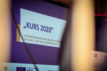 Das Foto zeigt einen Ausschnitt der Powerpointpräsentation der Auftaktkonferenz. Blauer Rahmen, weißer Hintergrund mit blauer Aufschrift 'Kurs 2020'. Bild: MF