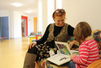 Das Bild zeigt Beate Malcher mit einem Mädchen, dass sich ein Buch anschaut. (Foto: Ministerium der Finanzen LSA)
