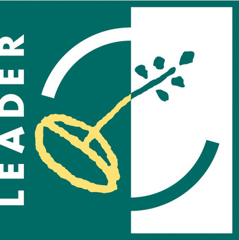 Das offizielle LEADER-Logo. Weiße, senkrechte Schrift auf grünem Grund. Daneben ein stilisiertes Weizenkorn aus dem ein Sproß treibt. 