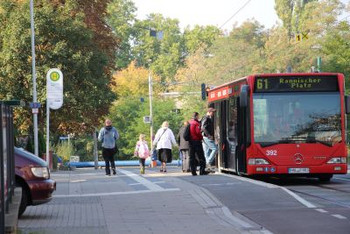 Auf dem Foto sieht man eine Bushaltestelle, mit einem wartenden roten Bus, der Richtung Rannischer Platz fährt und Menschen, die dabei sind, in diesen einzusteigen. (Foto: Ministerium der Finanzen LSA)